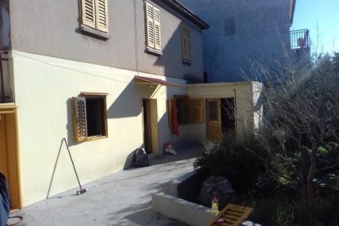 žuto bijela kuća prozori zeleni grm